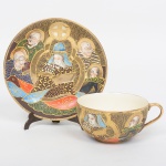 FAIANÇA JAPONESA, uma (1) xícara de chá, ornamentação policromada representando dignatários encimado pelo simbolo de Satsuma, estilo SHOZA (criado por Shoza na região de Kutani, em finais do período Edo no século XIX, com sua principal característica cores berrantes e generosos acabamentos a ouro, quando morreu em 1883 já tinha mais de 300 aprendizes o que fez com que o estilo perdurasse até a atualidade), pega da tampa relevada em cabeça de dragão celestial, manufatura J.H. dentro de um losango e a legenda Made in Japan, possui manchas e o craquelê característico do envelhecimento de toda a faiança, ideal para coleção de cristaleira, sinais de uso, vide foto.