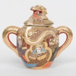 FAIANÇA JAPONESA, um (1) açucareiro com tampa, ornamentação policromada representando dignatários, estilo SHOZA (criado por Shoza na região de Kutani, em finais do período Edo no século XIX, com sua principal característica cores berrantes e generosos acabamentos a ouro, quando morreu em 1883 já tinha mais de 300 aprendizes o que fez com que o estilo perdurasse até a atualidade), relevado em dragão celestial, possui o craquelê característico do envelhecimento de toda a faiança, manufatura J.H. dentro de um losango e a legenda Made in Japan, medindo 16 cm altura, sinais de uso, vide foto.