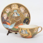 FAIANÇA JAPONESA, uma (1) xícara de chá, ornamentação policromada representando dignatários encimado pelo simbolo de Satsuma, estilo SHOZA (criado por Shoza na região de Kutani, em finais do período Edo no século XIX, com sua principal característica cores berrantes e generosos acabamentos a ouro, quando morreu em 1883 já tinha mais de 300 aprendizes o que fez com que o estilo perdurasse até a atualidade), pega da tampa relevada em cabeça de dragão celestial, manufatura J.H. dentro de um losango e a legenda Made in Japan, possui manchas e o craquelê característico do envelhecimento de toda a faiança, ideal para coleção de cristaleira, sinais de uso, vide foto.
