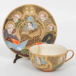 FAIANÇA JAPONESA, uma (1) xícara de chá (quebrada e colada), ornamentação policromada representando dignatários encimado pelo simbolo de Satsuma, estilo SHOZA (criado por Shoza na região de Kutani, em finais do período Edo no século XIX, com sua principal característica cores berrantes e generosos acabamentos a ouro, quando morreu em 1883 já tinha mais de 300 aprendizes o que fez com que o estilo perdurasse até a atualidade), pega da tampa relevada em cabeça de dragão celestial, manufatura J.H. dentro de um losango e a legenda Made in Japan, possui manchas e o craquelê característico do envelhecimento de toda a faiança, ideal para coleção de cristaleira, sinais de uso, vide foto.
