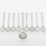 FAQUEIRO, conjunto para café com nove (9) itens: 1 concha para açucareiro e 8 colheres de café, confeccionadas em aço inox, manufatura HÉRCULES, cabos com ornamentação relevada em frisos e elementos vegetalistas, praticamente sem uso, medindo a maior peça 14 cm comprimento, vide foto.