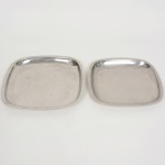 AÇO INOX, duas (2) travessas quadrangulares de tamanhos distintos, medindo 16,5 x 16,5 cm e 29 x 29 cm, ambas com sinais de uso, vide foto.