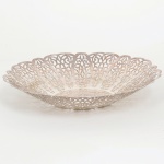 METAL PRATEADO, uma (1) pequena fruteira, borda recortada e vazada em elementos vegetalistas estilizados, sem marca de manufatura aparente, medindo 22,5 cm diâmetro, sinais de uso, vide foto.