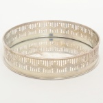 METAL PRATEADO, uma (1) salva circular, borda vazada em gradil e relevada em guirlandas de rosas, sem marca de manufatura aparente, medindo 15 cm diâmetro, sinais de uso, vide foto.