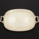 METAL PRATEADO, uma (1) bandeja retangular, borda reforçada no padrão Império napoleônico com frisos intercalados por X, alças na mesma padronização e com elementos vegetalistas, medindo 41 x 31 cm mais as alças, manufatura FRACALANZA (tradição dede 1884), sinais de uso, vide foto.