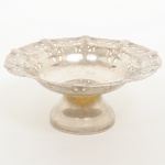 METAL PRATEADO, uma (1) pequena fruteira de pé alto, borda recortada e vazada em elementos vegetalistas, base ligeiramente cônica, manufatura PRATA REY-100, medindo 16 cm diâmetro e 7 cm altura, sinais de uso, vide foto.