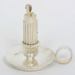 COLECIONISMO, um (1) antigo isqueiro da marca CURZON, formato de palmatória, confeccionado em metal prateado e outros materiais, medindo 6,5 cm altura, funcionamento não testado, sinais de uso, vide foto.