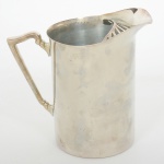 METAL PRATEADO, uma (1) jarra refresqueira, cilíndrica, possui retentor de gelo, alça terminando em volutas, manufatura BELPRATA, medindo 18 cm altura, sinais de uso, vide foto.