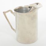 METAL PRATEADO, uma (1) jarra refresqueira, cilíndrica, possui retentor de gelo, alça terminando em volutas, manufatura BELPRATA, medindo 18 cm altura, sinais de uso, vide foto.
