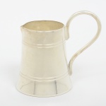 METAL PRATEADO, uma (1) cremeira miniatura, formato de caneco, ligeiramente cônica, frisos horizontais, alça sinuosa, marca GS (Industria Argentina), padrão Inglês Georgiano, medindo 6,5 cm altura até a alça, sinais de uso, vide foto.