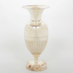 METAL PRATEADO, um (1) vaso floreiro, metade inferior do bojo canelado, encimado por corneto, base em perolados, manufatura EBERLE (Abramo Eberle 1880, Monte Magrè 1945, Caxias do Sul, veio com uma das primeiras levas de imigrantes italianos para o Brasil em 1884 junto com seus pais Giuzeppe Eberle e Luigia Zanrosso, seu pai abriu uma pequena funilaria mas como tinha que trabalhar na lavoura quem cuidava era a mãe e o pequeno Abramo ajudava na funilaria; em 1896 quando o pai resolveu vender a funilaria para concentrar os esforços da família na lavoura Abramo, com 16 anos de idade, se propôs a comprá-la do pai, em 1918 já com o nome Abramo Eberle & Cia iniciou a fabricação de talheres e utensílios de mesa, morreu em 1945 com 65 anos de idade e os filhos deram continuidade aos negócios até 1984 quando venderam para o Grupo Zivi), medindo 24 cm altura, sinais de uso, vide foto.