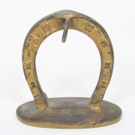 BRONZE, um (1) suporte expositor e despojador para relógio de algibeira, formato de ferradura, medindo 8,5 cm altura, sinais de uso, vide foto.