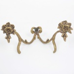 BRONZE, um (1) suporte expositor para prato ou travessa, confeccionado em bronze, relevado em flores, medindo 15 cm, sinais de uso, vide foto.