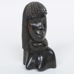 ARTE TRIBAL AFRICANA, uma (1) escultura figurativa representando cabeça feminina, entalhada em ébano, traz selo do Patrimônio Cultural  Exportação Autorizada, medindo 18 cm altura, vide foto.