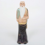 ESCULTURA, uma (1) figurativa masculina, representando Dignatário Oriental, confeccionada em porcelana policromada, medindo 19 cm altura, vide foto.