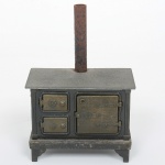 BRINQUEDO, uma (1) miniatura de fogão a lenha para casa de boneca, confeccionado em metal, medindo 10 x 6 x 14,5 cm, vide foto.