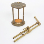 SUCATA, duas (2) partes distintas em metal: 1 de cano, marca Buffalo Dental Mfg. Co., confeccionado em bronze, com duas torneiras para regular saída, medindo 32 cm; 1 suporte para ampulheta, faltando o vidro com areia, medindo 14,5 cm altura, ambos com sinais de uso, vide foto.