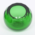 VIDRO, um (1) cinzeiro quase esférico, verde e translúcido, borda com lapidação dita dedão, corte diagonal, medindo aproximadamente 9 cm altura e 10 cm diâmetro, sinais de uso, vide foto.