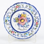 FAIANÇA PORTUGUESA, um (1) prato decorativo pintado a mão com flores em policromia, borda vazada, souvenir de Cascais, medindo 14 cm diâmetro, vide foto.