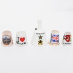 COLECIONISMO, cinco (5) itens: 4 dedais e 1 sineta, confeccionados em porcelana, todos souvenires de regiões diversas: Thailândia; Marrocos; Inglaterra; Hungria e Praga, medindo a maior peça 5,5 cm altura, vide foto.