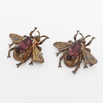 JOIA, par (2) antigos broches no formato de abelha, confeccionados em PRATA dourada, apliques em vidro facetado, um deles com placa da STERLING BY CORO (CoHn & Rosenberger, funda a no ano de 1901/2 em New York por Emanuel Cohn e Carl Rosenberger; em 1911 abriram uma fábrica em Providence, Rhode Island; em 1913 foi incorporada; em 1943 foi adotado o nome CORO; em 1969 a família vendeu 51% das ações para a Richton International; em 1970 a Coro Incorporation adquiriu os 49% restantes; em 1979, todas as empresas da CORO faliram exceto uma no Canadá; em 1992 foi vendida para uma Companhia Sul Americana que também faliu), medindo aproximadamente 3 x 3 cm, peso total 8,8 gr., sinais de uso, vide foto.