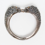 JOIA, um (1) bracelete em PRATA, representando cabeças leoninas, detalhes em dourado, medida interna aproximada 5 cm diâmetro, peso 58,7 gr., vide foto.