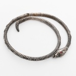 JOIAS, uma (1) pulseira em PRATA, formato de serpente, pequenos defeitos, olhos com pedras facetadas vermelhas, tamanho regulável, peso 10,7 gr., sinais de uso, vide foto.