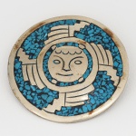 JOIA MEXICANA, um (1) broche/pingente confeccionado em alpaca (liga de prata de baixíssimo teor), apliques em cascalhos de turquesas, medindo 44 mm diâmetro, sinais de uso, vide foto.