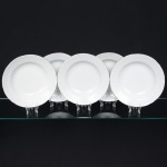 Porcelana Beatriz, Natal - RN. Elegante conjunto de pratos fundos em porcelana nacional, esmaltagem vítrea na cor branca, decoração na técnica "bianco sopra bianco", com padrão floral e 'lattice' em reserva relevados na prória pasta, distribuídos ao redor da orla, borda recortada e contornada por friso prateado. Marca da manufatura no verso. Composto de cinco(05) unidades. Medida: Diam.: 22,5 cm.