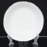 Porcelana Beatriz, Natal - RN. Bowl em porcelana nacional, formato hemisférico, esmaltagem vítrea na cor branca, decoração na técnica "bianco sopra bianco", com padrão floral e 'lattice' em reserva relevados na prória pasta, borda recortada e contornada por friso prateado. Marca da manufatura no verso. Medidas.: Alt.: 7 x Diam.: 23,5 cm.