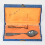 WOLFF. Conjunto para viagem confeccionado em metal espessurado à prata, composto de uma(01) colher e uma(01) espátula; cabo de ponta arredondada, lavrada com imagem de pássato pousado sobre galhos e folhagens. Marca da manufatura puncionada no verso do cabo. Acondicionado em estojo. Medidas: Comp.: 9 cm; Comp.: 15 cm.