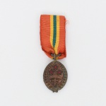 Medalha de Sangue do Brasil criada por intermédio do Decreto-Lei nº 7.709, de 5 de julho de 1945 com o objetivo de a agraciar oficiais, praças, assemelhados e civis, destacados para o teatro de operações na Itália(II GM), e que ali tivessem sido feridos em consequência de ação objetiva do inimigo. O decreto-lei foi promulgado por Getúlio Vargas. Medalha confeccionada em  bronze, possui as seguintes características: Anverso: Sabre das Armas da República. Três estrelas vermelhas representando os três ferimentos recebidos pelo General Sampaio, no dia 24 de maio de 1866, na Batalha de Tuiuti  Guerra do Paraguai. Dois ramos de "Pau Brasil", orlando a medalha, lembram a Pátria e as origens de seu nome glorioso. Uma faixa arqueada está inscrita  Sangue do Brasil. Reverso: esfera da Bandeira Nacional envolvida pelos dois ramos de "Pau Brasil". A fita é de cor vermelha com um friso central, dividido em três partes iguais com as cores nacionais: amarelo, verde, amarelo. Estado conforme fotografias. Medidas: Medalha: Alt.: 2 x Comp.: 1,9 cm. Comp.: 5 cm.