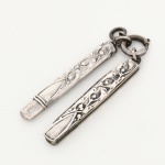 Conjunto para escrita com canivete e pequeno lápis em prata alemã  estilo Art Nouveau.Cabos confeccionados em prata, contraste Halbmond und krone(lua a coroa), marca de garantia da prata do toque 0,800; superfície decorada em relevo com motivos vegetalistas sinuosos, compostos por hastes alongadas, folhagens estilizadas e elementos orgânicos em composição assimétrica. Canivete com lâmina de aço, articulada, apresentando leve oxidação. Medidas: Canivete(aberto): 7,5 cm; Lápis: Comp.: 6 cm.