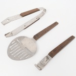 HERCULES INOX. Um(01) pegador de gelo, um(01) abridor de garrafa e uma(01) espátula em aço inoxidável, com cabos anatômicos em madeira fixados por rebites metálicos. Medidas: Comp.: 15 cm; Comp.: 17 cm; Alt.: 20 x Comp.: 9 cm.