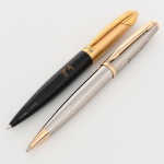 Dois(02) itens: a) Caneta esferográfica de corpo em resina sintética preta, formato ogival alongado, com extremidade inferior afilada e ponta metálica cônica. Seção superior e tampa em metal dourado, com clipe integrado de perfil aerodinâmico, ostentando logomarca estilizada em relevo na extremidade. Anel de junção também em metal dourado, gravado VICTOR em caracteres impressos. Sistema de acionamento por torção, com mecanismo interno retrátil para projeção da carga esferográfica. Medida: Comp.: 14 cm; b) Caneta esferográfica de corpo metálico em aço escovado, perfil fusiforme alongado, com seção inferior afilada e ponteira cônica em metal dourado polido. Tampa metálica em aço escovado, com extremidades e anéis de acabamento em metal dourado. Clipe metálico dourado, de seção plana e perfil curvo, aplicado à tampa. No corpo, gravação com inscrição PROCIMAX acompanhada de logomarca estilizada. Sistema de acionamento por torção, com mecanismo interno retrátil para projeção da carga esferográfica. Medida: Comp.: 14 cm. Necessitam troca de carga.