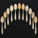 RADIO ALPACA. Conjunto de colheres médias confeccionadas em alpaca espessurado à prata, cabo de ponta oval, ricamente relevado com folhas de acanto e borda contornada por fileira perlada. Marca da manufatura puncionada no verso. Composto de onze(11) unidades. Apresentam marcas de uso e do tempo, vide foto. Medida: Comp.: 17,5 cm.