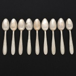 RADIO ALPACA. Conjunto de colheres para chá confeccionadas em alpaca espessurado à prata, cabo de ponta oval, ricamente relevado com folhas de acanto e borda contornada por fileira perlada. Marca da manufatura puncionada no verso. Composto de dez(10) unidades. Apresentam marcas de uso e do tempo, vide foto. Medida: Comp.: 11,5 cm.