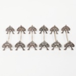 Elegante conjunto de descansos para talher confeccionado em metal espessurado à prata, haste tubular com suportes laterais em forma de folha, cinzelada e decorada com heras em relevo. Composto de seis(06) unidades. Med.: Alt. 3,5 x Comp. 8 x Larg. 3 cm.