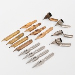 Dezesseis(16) penas metálicas para escrita (bicos de pena), manufaturas diversas, finais do século XIX e primeira metade do século XX. Lote composto por penas de aço para caneta de pena mergulhável, de diferentes modelos e fabricantes, incluindo exemplares dourados (aço com revestimento) e exemplares niquelados. Corpos estampados e conformados em chapa metálica, providos de fenda longitudinal de flexão, orifício de ventilação e talão cilíndrico destinado à inserção em porta-pena. Entre os fabricantes, constam exemplares marcados John Heath, modelo 808, com indicação Hemisperical Point, produzidos na Inglaterra; D. Leonardt & Co., Birmingham; e marcados E.S. Perry, modelo Iridinoid, Inglaterra. O conjunto inclui ainda pontas metálicas anguladas para pena técnica ou caligráfica, destinadas à fixação em suporte específico, utilizadas em escrita ornamental ou desenho técnico. Apresentam sinais de oxidação, visíveis nas fotografias. Medidas: Comp.: 3,8 cm; Comp.: 4 cm.