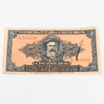 Bônus do Thesouro do Estado de São Paulo  Revolução Constitucionalista. Título fiduciário emitido pelo Tesouro do Estado de São Paulo durante o contexto da Revolução Constitucionalista de 1932. Cédula no valor de Cinco Mil Réis (5$000), identificada como Bônus do Thesouro do Estado  Pró Constituição, destinada ao financiamento do movimento constitucionalista paulista. Anverso com medalhão central contendo o retrato de Domingos Jorge Velho, bandeirante associado à expansão territorial paulista, ladeado por cartelas ornamentais com o numeral do valor. Na parte superior lê-se Thesouro do Estado de S. Paulo, Brazil, com numeração tipográfica em vermelho Nº 613440. Abaixo do retrato consta a legenda Cinco Mil Réis e inscrição indicando o resgate pelo Tesouro do Estado conforme Decreto nº 5585 de 14 de julho de 1932. Reverso com composição tipográfica central contendo a inscrição Bonus do Thesouro do Estado  Pro Constituição  São Paulo, acompanhada de numerais laterais do valor e fundo ornamental guilhochê. Peça integrante das emissões emergenciais realizadas pelo governo paulista durante o conflito de 1932, utilizadas como instrumento financeiro e meio de arrecadação para sustentar o esforço político-militar do movimento constitucionalista. Estado conforme fotografias, apresenta rasgo no meio.