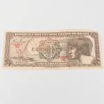 Cédula  Cinco Cruzeiros  República dos Estados Unidos do Brasil. Papel-moeda emitido pelo Tesouro Nacional do Brasil e impresso pela Casa da Moeda do Brasil, pertencente à primeira série do cruzeiro introduzida pela reforma monetária de 1942. Anverso com composição em moldura geométrica e fundo guilhochê, apresentando medalhão inferior com busto feminino alegórico representando a República. No campo superior figura vinheta ilustrando pescador em embarcação lançando rede em ambiente fluvial. Ao centro lê-se a inscrição Cinco Cruzeiros, acompanhada da legenda República dos Estados Unidos do Brasil. Numeração tipográfica em vermelho nº 070256, com indicação Estampa 3  Série 034. Reverso com composição monocromática em tom castanho, exibindo ao centro representação botânica da vitória-régia (Victoria amazonica), inscrita em cartela com a legenda Vitória-Régia. Moldura decorativa geométrica com repetição do numeral 5 e inscrição Estados Unidos do Brasil. Cédula emitida na década de 1940, no período inicial do sistema monetário do cruzeiro (19421967), caracterizada por impressão calcográfica, fundos de segurança guilhochados e iconografia naturalista associada à paisagem brasileira. Estado conforme fotografias.