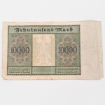 Alemanha - 10.000 Mark (Zehntausend Mark), República de Weimar. Cédula emitida pela Reichsbank, datada de 19 de janeiro de 1922, pertencente às emissões fiduciárias do período inflacionário da República de Weimar. Impressão em papel fiduciário com composição ornamental guilhochê e tipografia em caracteres góticos. Anverso: campo central com a inscrição Reichsbanknote Zehntausend Mark, acompanhada da fórmula de pagamento ao portador e data de emissão em Berlim. Série alfanumérica impressa em vermelho (Z 0082396). Selos circulares com águia germânica. À direita, painel figurativo contendo busto de Albrecht Dürer, gravador e pintor alemão do Renascimento, em medalhão lateral. Valor facial 10000 inscrito em cartela oval inferior e repetido em cartelas ornamentais. Reverso: composição simétrica em guilhochê com águia imperial estilizada ao centro, ladeada por cartelas ornamentais contendo o valor 10000 e inscrições Zehntausend Mark. Peça pertencente às emissões fiduciárias alemãs produzidas durante o processo inflacionário que antecedeu a hiperinflação de 1923, período caracterizado por sucessivas emissões de altas denominações monetárias. Alemanha, 1922. Estado conforme fotografias.