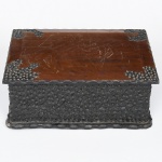 Caixa de formato retangular construída em madeira, com tampa plana articulada por dobradiças metálicas, superfície externa apresenta trabalho entalhado em relevo de textura pontilhada, obtido por técnica de escavação manual, criando efeito rústico e irregular nas laterais da peça, base moldurada acompanhando o contorno retangular da peça. Verso com etiqueta original do fabricante, identificando: Storil Peixoto & Cia Ltda  Artefatos de Madeira  Campo Grande  Indústria Brasileira.  Apresenta ranhuras e marcas de uso, vide foto. Medidas: Alt.: 13 x Comp.: 35 x Larg.: 23 cm.