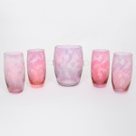 Conjunto da década de 1960 em vidro, coloridos com tonalidade rosa, talhados com flores e elementos vegetalistas. Composto de uma(01) geleira e quatro(04) copos. Medidas: Geleira: Alt.: x Diam.: Copos: Alt.: x Diam.: