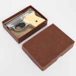 Pistola de alarme modelo Walther U.P. Mod. 1, acompanhada de estojo, semiautomática com estrutura metálica de acabamento niquelado, apresentando empunhadura com talas em material sintético de coloração marfim texturizada, fixadas por parafuso central. Corpo com inscrições gravadas Walther U.P. Mod. 1  Walthers Patent, além da marcação E S na porção posterior do ferrolho. Cano curto e sistema de alimentação por carregador destacável de múltiplas câmaras, destinado ao uso de cartuchos de alarme (festim) de pequeno calibre, sem projétil, próprios para produção de estampido sonoro. Este tipo de arma era destinado à sinalização acústica, sendo empregado em largadas esportivas, treinamento e adestramento, bem como em usos recreativos ou demonstrativos. Acompanha estojo original apresentando inscrição Walther U.P. Model 1 na parte superior. Não foi testada. Estado conforme fotografias. Medidas: Alt.: 8 x Comp.: 11 cm.