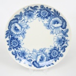 KPM - Königliche PorzellanManufaktur Berlin - Alemanha(Fundada em 1763 por Frederico, o Grande). Prato medalhão de coleção em porcelana alemã, esmaltação vítrea de tom marfim, decoração composta por flores estilizadas, folhas e botões dispostos em composição circular ao longo da aba, executados em tonalidades graduadas de azul cobalto. Marca da manufatura no verso. Medida: Diam.: 32 cm.