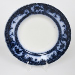 Fábrica de Loiça de Sacavém (Gilman & C.ª), Sacavém, Portugal. Manufatura fundada em 1850 por John Stott Howorth e posteriormente administrada por William Gilman, com produção de faiança fina e grés, adotando processos industriais de moldagem e decoração por estampagem. Belíssimo prato fundo em faiança portuguesa, com aba larga e borda recortada. Dotada de decoração obtida por transferência(transfer printing) em monocromia azul cobalto, aplicada sob o vidrado (underglaze), apresentando motivos vegetalistas em reservas e cartelas distribuídas na aba e friso interno contínuo. Marca sob a base em azul: BEIRA / GILMAN & C.ª / SACAVÉM / PORTUGAL. Medida: Diam.: 24,5 cm.