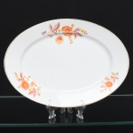 Jean Haviland, Limoges - França. Belíssima travessa oval executada em porcelana francesa da década de 1950/60; centro ligeiramente rebaixado, esmaltagem vítrea na cor branca, decoração em estampagem policromada, composta por ramagens florais estilizadas distribuídas assimetricamente na aba, borda contornada por friso em douradura. Marca da manufatura no verso. Medidas: Comp.: 28 x Larg.: 20 cm. Apresenta leves desgastes na policromia e na douradura.