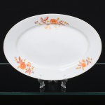 Jean Haviland, Limoges - França. Belíssima travessa oval executada em porcelana francesa da década de 1950/60; centro ligeiramente rebaixado, esmaltagem vítrea na cor branca, decoração em estampagem policromada, composta por ramagens florais estilizadas distribuídas assimetricamente na aba, borda contornada por friso em douradura. Marca da manufatura no verso. Medidas: Comp.: 29,5 x Larg.: 21 cm. Apresenta leves desgastes na policromia e na douradura.