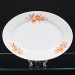 Jean Haviland, Limoges - França. Belíssima travessa oval executada em porcelana francesa da década de 1950/60; centro ligeiramente rebaixado, esmaltagem vítrea na cor branca, decoração em estampagem policromada, composta por ramagens florais estilizadas distribuídas assimetricamente na aba, borda contornada por friso em douradura. Marca da manufatura no verso. Medidas: Comp.: 32 x Larg.: 22,5 cm. Apresenta leves desgastes na policromia e na douradura.